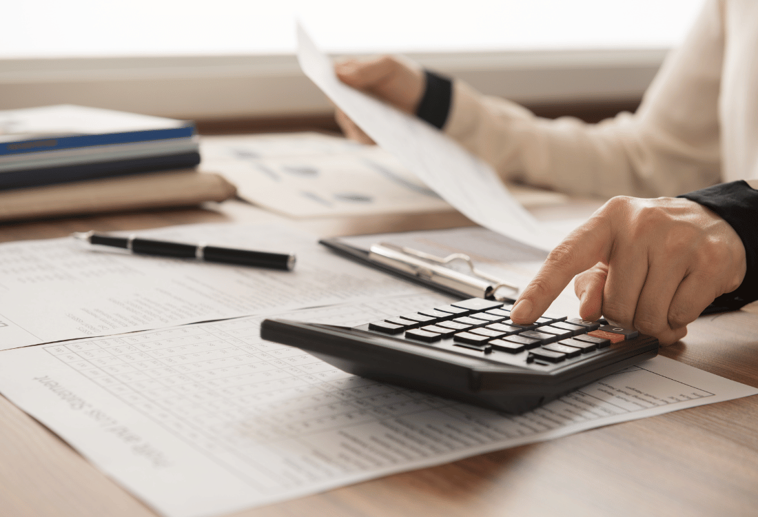 A person using a calculator while they create a financial plan to analyse.